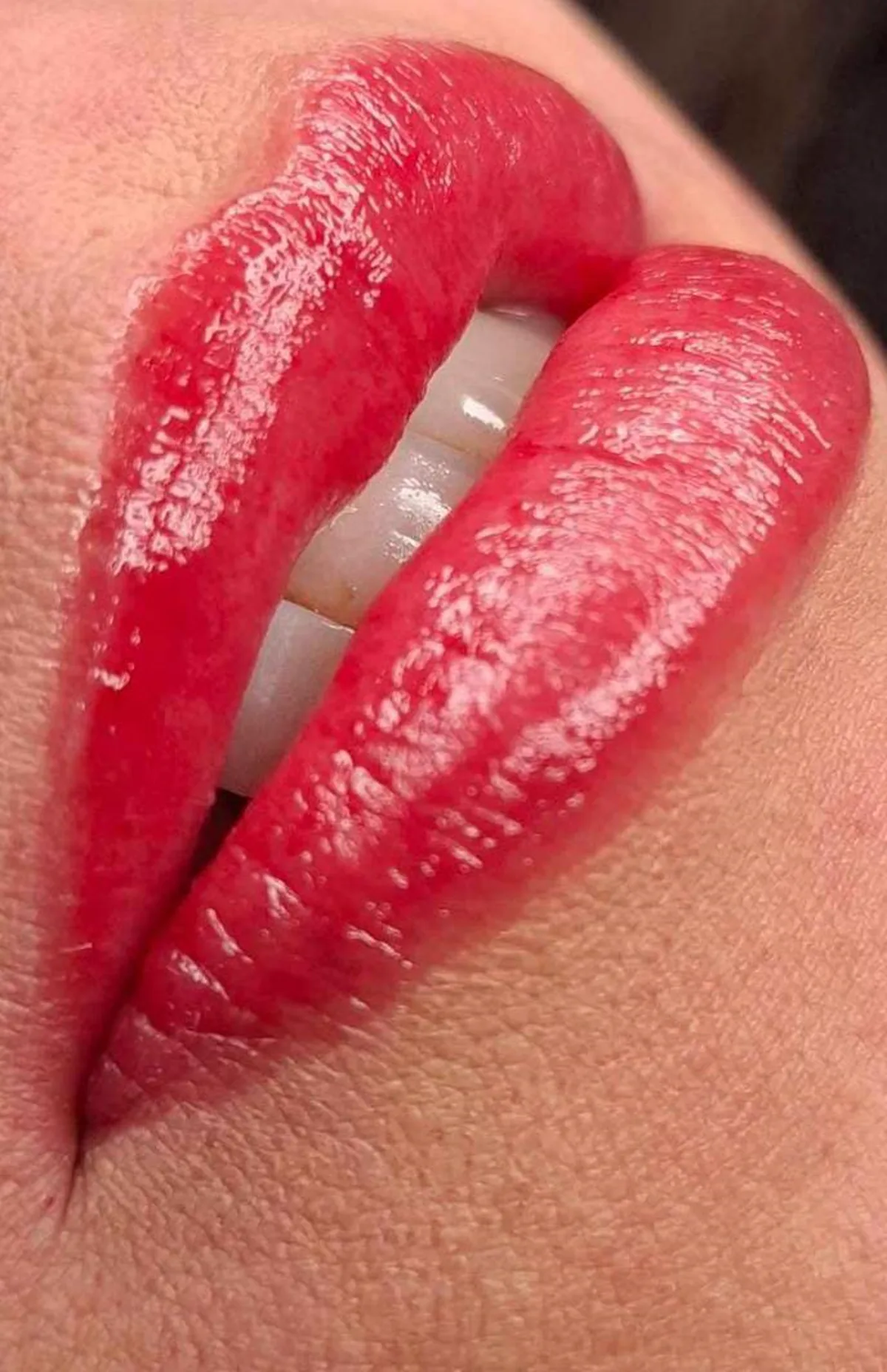 Detalle de labios con micropigmentación en tono rojo coral